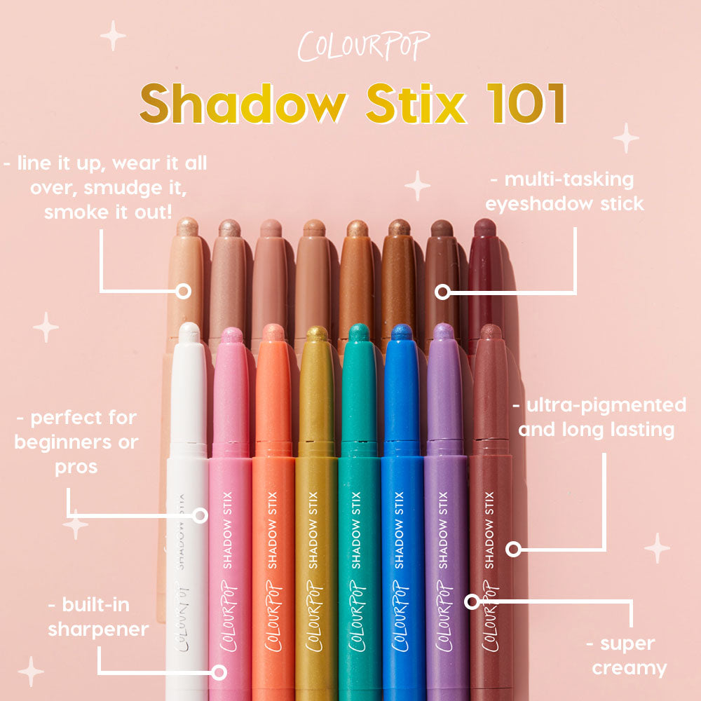 ColourPop Shadow Stix in Socialite stands uncapped among a rainbow lineup of creamy eyeshadow sticks on a pink backdrop, showcasing its multitasking wear, built‑in sharpener, and ultra‑pigmented, long‑lasting formula.