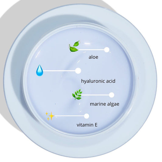 Soak It Up Hydrating Mask, a ColourPop Face Mask, displayed in an open jar of pale lavender gel, highlights ingredients with callouts - aloe, hyaluronic acid, marine algae, and vitamin E - on a white dish under bright light.