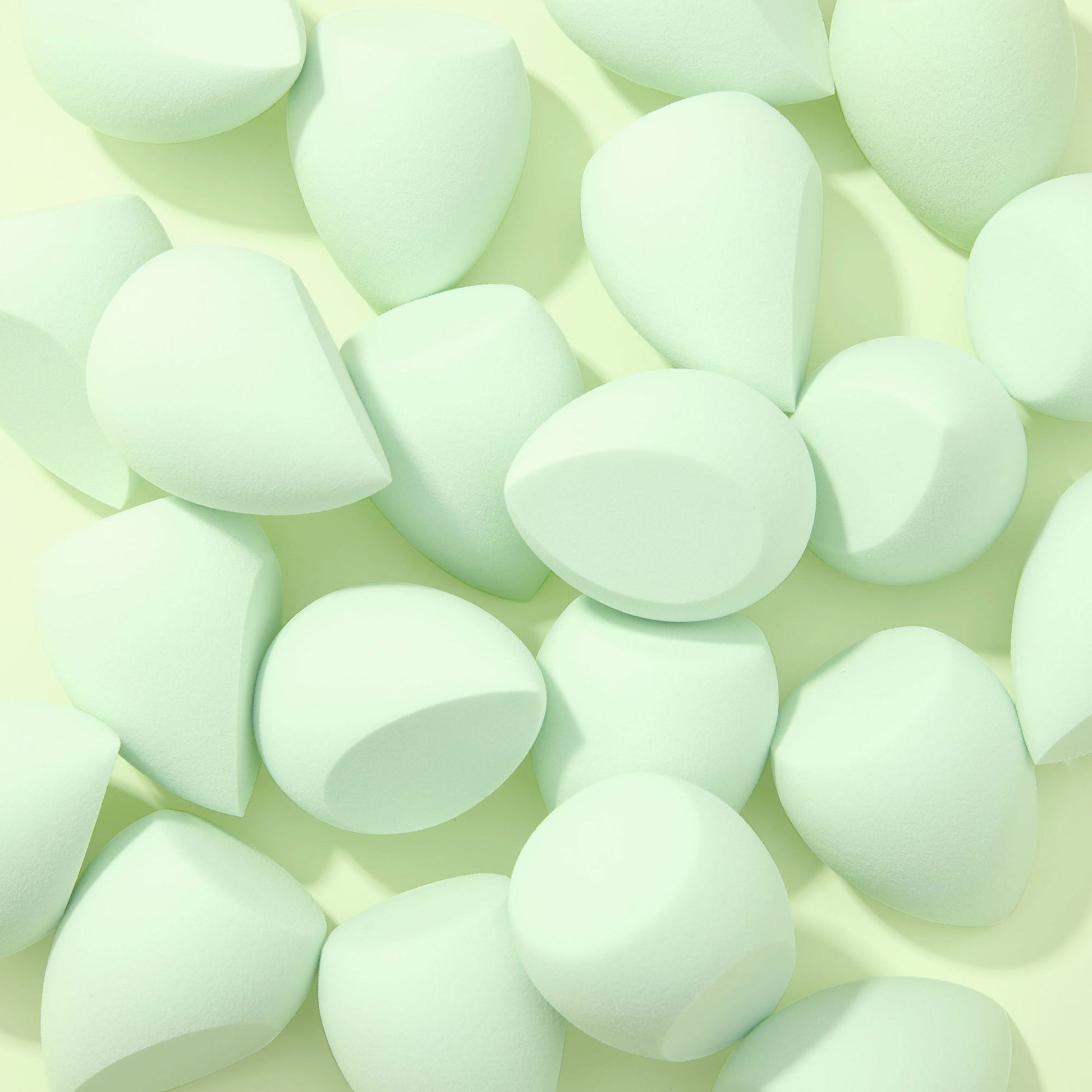 Complexion Blending Sponge set scattered across a pale mint background, mint green teardrop sponges with flat edges and rounded tips, soft foam for seamless foundation blending; ColourPop Makeup Tools & Accessories.