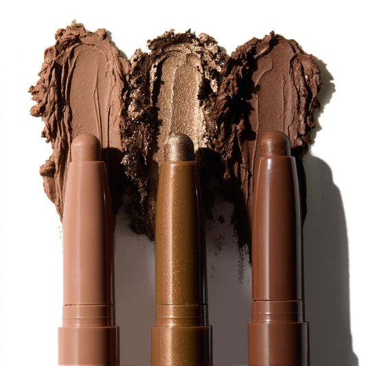 Essential Neutrals ColourPop Shadow Stix set swatched - three creamy eyeshadow sticks in matte taupe, shimmer bronze, and deep chocolate - displayed with smears behind the tips on white to show blendable, long-wear color.