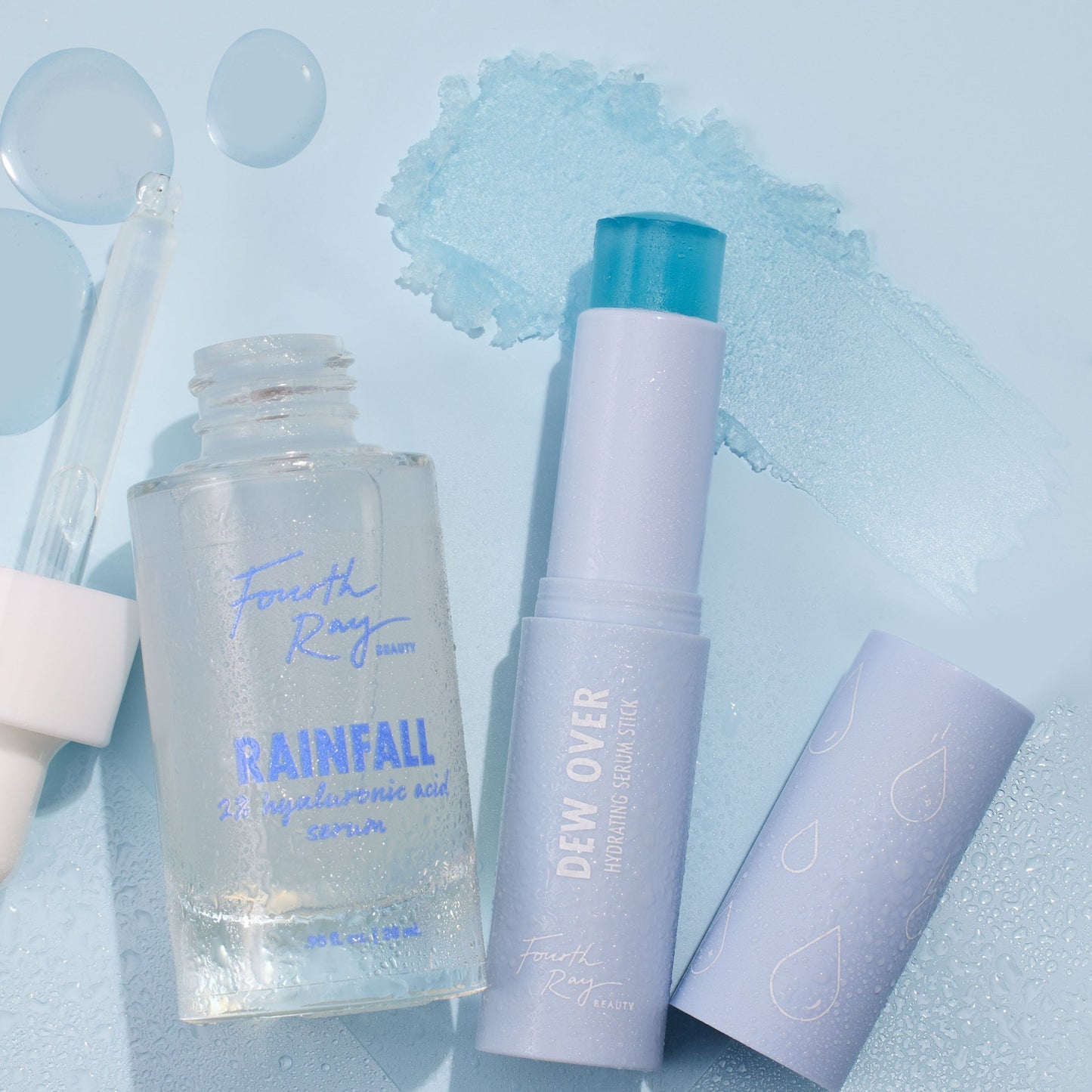 Hydration Station ColourPop Face Set showcasing Fourth Ray Beauty Rainfall 2% hyaluronic acid serum with dropper and Dew Over hydrating serum stick, both dewy and open beside an icy blue swatch on a light blue background.