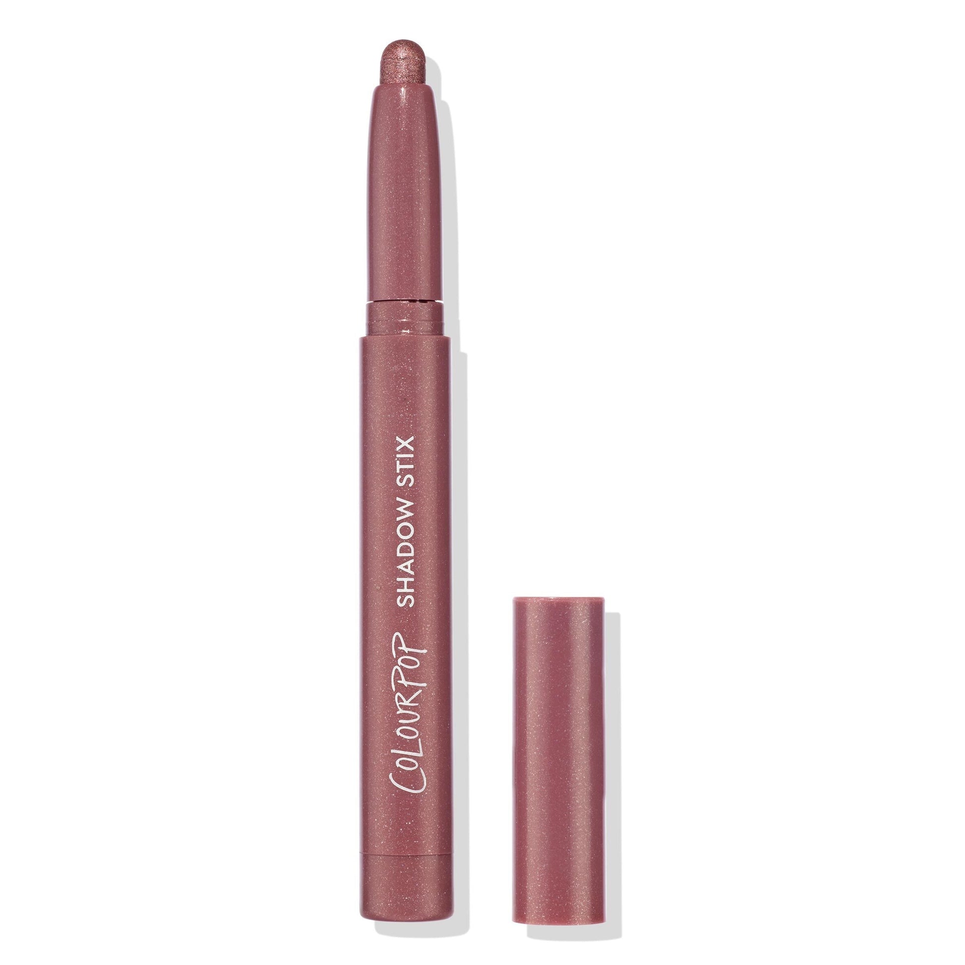 ColourPop Shadow Stix in Next Spot stands uncapped with the rounded shimmer tip exposed, showing a rosy mauve metallic shade; slim pencil with ColourPop Shadow Stix branding, cap beside it on a clean white background.