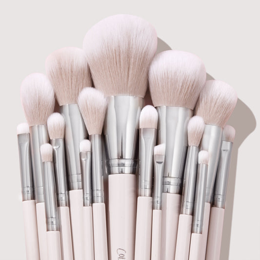 Stone Cold ColourPop Makeup Brush Kit fanned upright, displaying powder, blush, contour, and eye brushes with fluffy blush-pink bristles, silver ferrules, and pale pink handles, stacked tightly against a soft beige backdrop.
